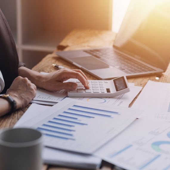 Businesswoman or accountant working Financial investment on calculator, calculate, analyze business and marketing growth on financial document data graph, Accounting, Economic, commercial concept.