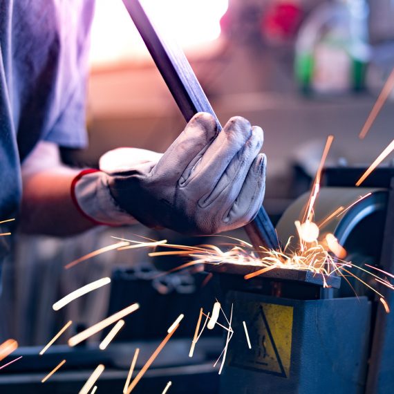 Worker polishes on a belt grinder. Template, mockup.